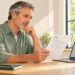 Man reviewing a PSA laboratory report beside a laptop.